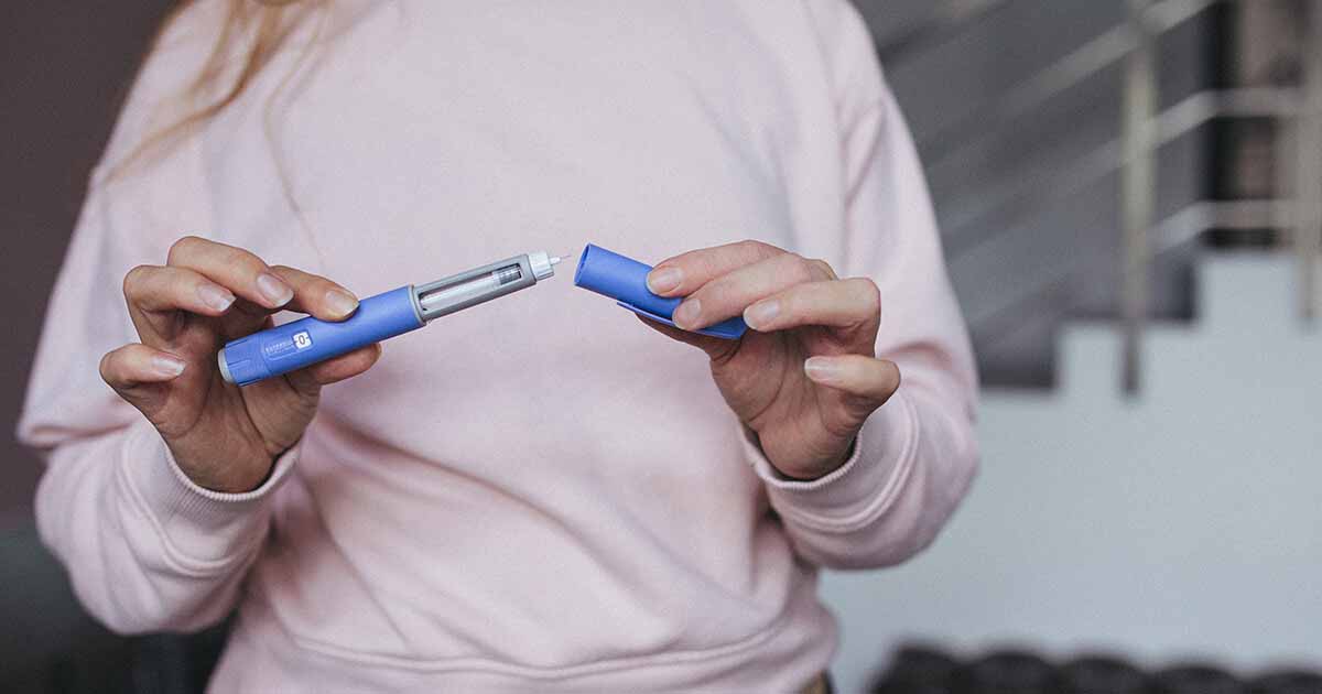 Person holding injectable drug dispenser