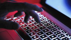 Hand typing on dark keyboard