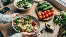 Hands holding a plate of healthy foods