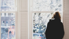 Person staring forlornly out a window
