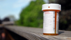 Prescription pill bottle on a porch railing