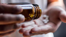 Hands pouring out a bottle of pills
