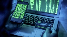 Hacker on smart phone and computer