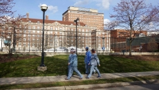 Workers walk past Henry Ford Health 