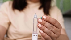 A woman holds an injectable medicine