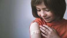 Child with bandaid after getting a vaccine