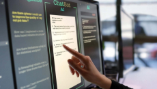 A finger points to text on a screen