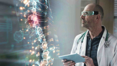 Doctor wearing VR glasses examines 3-D model of spine