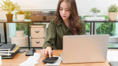 Person using a calculator and a computer