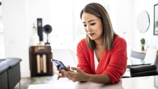 Person at home desk using phone