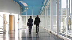 Execs walking through hospital corridor.