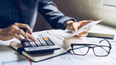 Person at desk with papers and a calculator