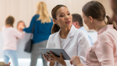Healthcare worker with tablet talking to patient
