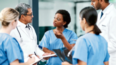 Healthcare professionals in discussion, standing in a circle