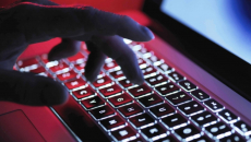 Hand typing on laptop keyboard