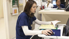 A clinician concentrating on her computer screen