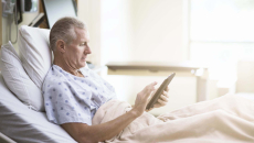 Patient using tablet in a hospital bed