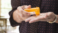 Person pouring pills into hand