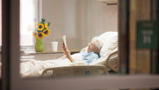 Person reads in hospital bed