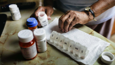 Hands with pill organizer and bottles