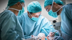 An operation setting with three medical professionals. Photo: Morsa/Getty Images