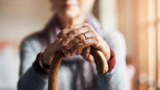 Person's hands rest on a cane. Photo: Cecilie Arcurs/Getty Images