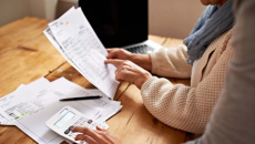 People examine paperwork with calculator