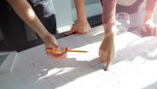 Hands pointing over blueprints