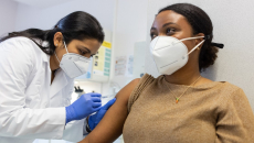 Healthcare worker in mask vacinating patient in mask