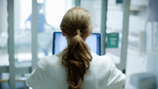 health professional facing a screen