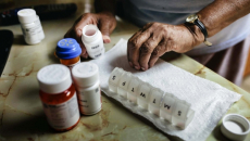 Hands sorting through pillbox