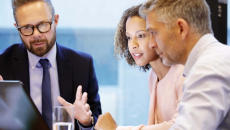A business meeting with three people at a table