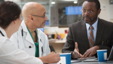 Three hospital executives meet at a table