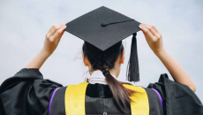 Graduate in robes holding cap