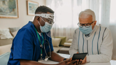 Health professional and patient looking at tablet