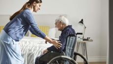 Someone helping a senior in a wheelchair