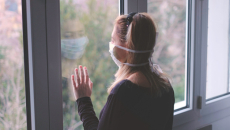 Person wearing mask at window
