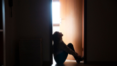 Person sitting on floor in a doorway