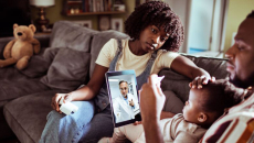 Parent and child with tablet showing healthcare professional