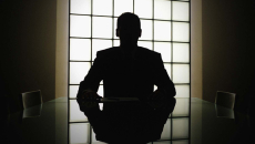 Silhouette of executive looking out window