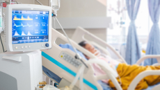 Patient in hospital bed with a monitor