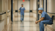 Healthcare worker sits in hospital corridor