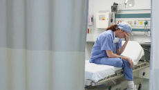 Exhausted medical worker sits on hospital bed