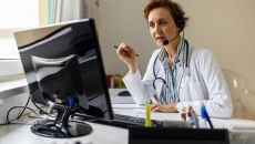 Doctor at screen with headphones