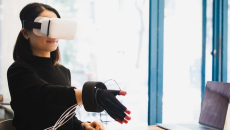 Person wearing VR goggles and glove
