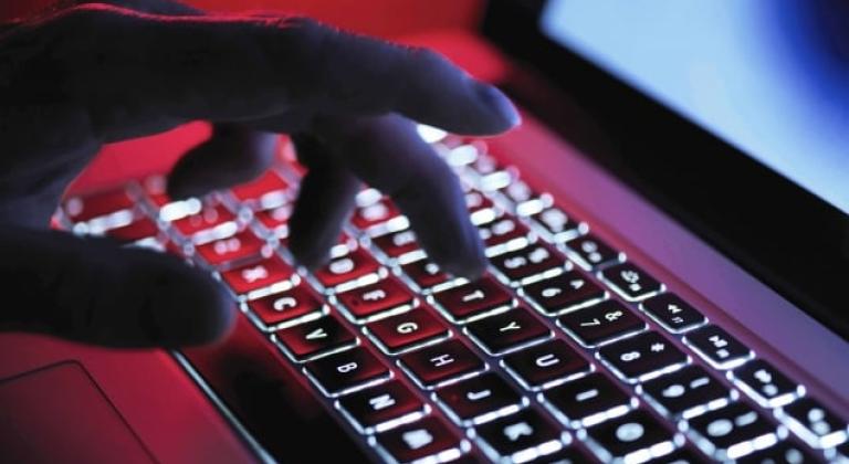 Hand typing on laptop keyboard