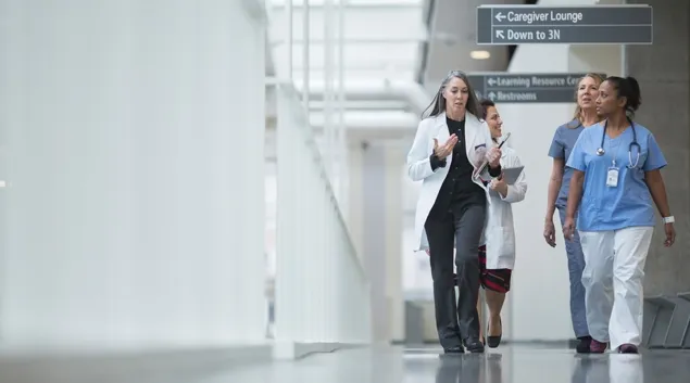 Clinicians walking down a hospital corridor Clinicians walking down a hospital corridor