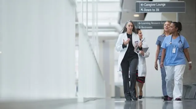 Clinicians walking down hospital corridor Clinicians walking down hospital corridor