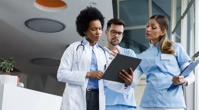 Clinicians consulting a clipboard Clinicians consulting a clipboard