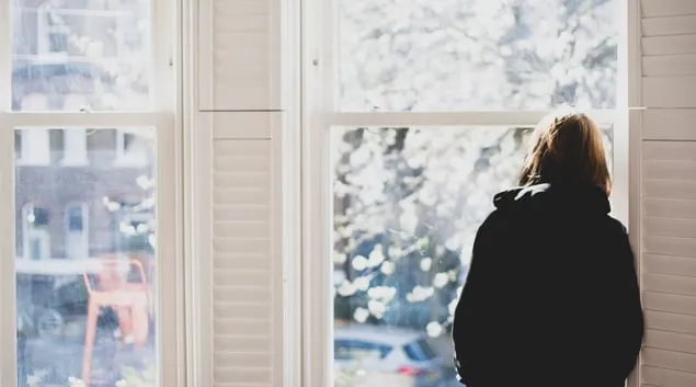 Person staring forlornly out a window Person staring forlornly out a window
